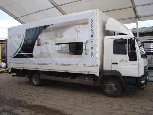 Plandeka reklamowa na naczepie samochodu ciężarowego marki MAN le180c.