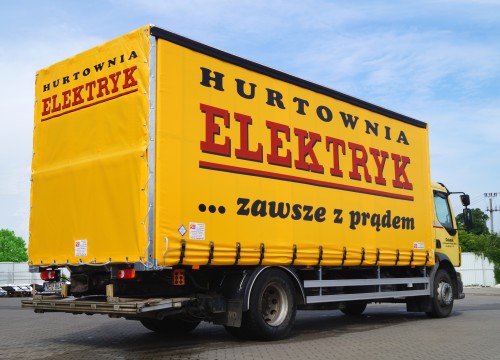 Plandeka reklamowa na zabudowie skrzynowej samochodu ciężarowego Volvo FL 280.