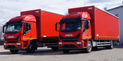 Czerwona plandeka na naczepie znajdującej się na podwoziu samochodu ciężarowego marki IVECO EUROCARGO 180-280. 