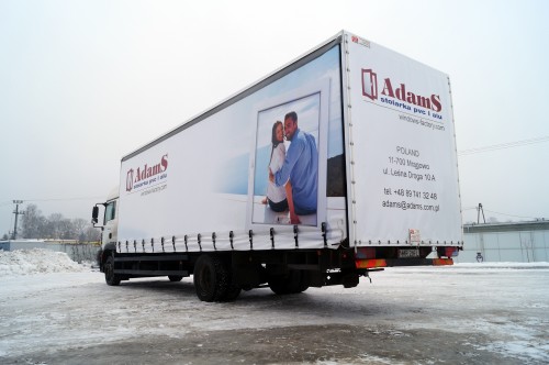 Plandeka reklamowa dla firmy Adams, znajdująca się na podwoziu samochodu ciężarowego MAN TGM 18.330.