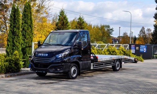 Czarna laweta Iveco Daily w jesiennej scenerii