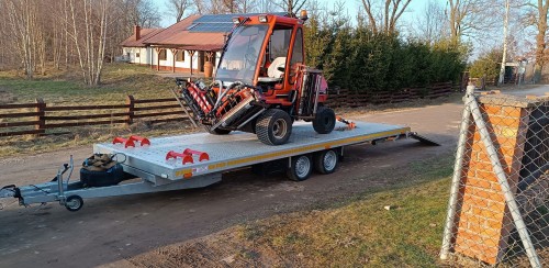 Transport maszyn rolniczych na przyczepie dwuosiowej marki Budocar